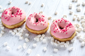 Banner with donuts on a wooden background. Photo of donuts and marshmallows on a wooden background.
