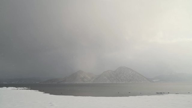 Nakajima island from Lake Toya under snow fall, Hokkaido, Japan