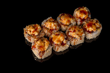 Hot fried Sushi Roll with perch, tobiko caviar, avocado and cheese on black background. Sushi menu. Japanese food. 