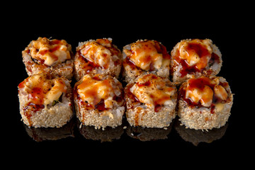 Hot fried Sushi Roll with smoked eel, shrimp, cheese and avocado on black background. Sushi menu. Japanese food. 