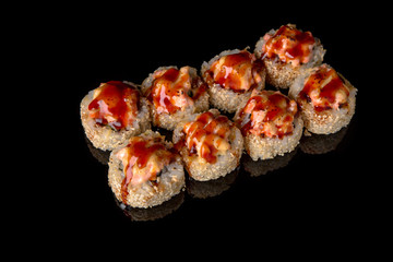 Hot fried Sushi Roll with eel, smoked salmon, cheese and avocado on black background. Sushi menu. Japanese food. 