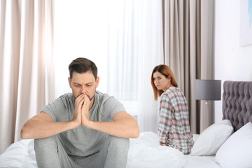 Couple with relationship problems ignoring each other in bedroom