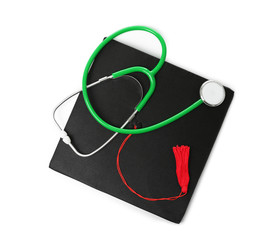 Stethoscope and graduation hat on white background, top view. Medical students stuff