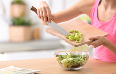 Young woman in fitness clothes preparing healthy breakfast at home, closeup
