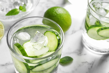 Glass with fresh cucumber water on table, closeup. Space for text