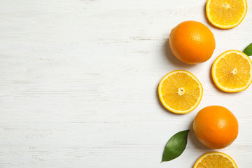 Flat lay composition with fresh oranges on wooden table. Space for text