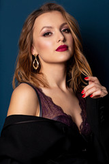 Naklejka premium Beauty portrait of lovely blonde model with perfect makeup wearing lace lingerie and jacket