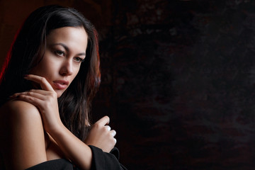 Fototapeta premium Closeup portrait of seductive model with naked shoulders, posing with red light. Space for text