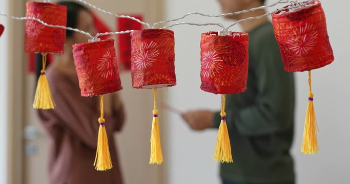 Man giving red packet to woman with the chinese new year decoration at home