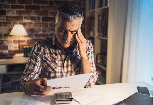 Worried man checking his domestic bills at home