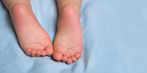 Little barefeet. Baby crawling on bed. Baby's feet. Barefeeted baby. Children's feet.