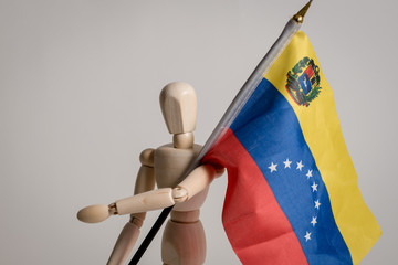 Venezuelan flag held by man made in wood on white background ideal for political and social...