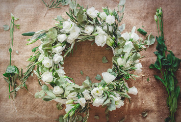 Wreath with white roses on jute background