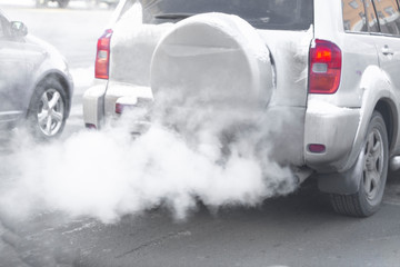 pollution from the exhaust of cars in the city in the winter. Smoke from cars on a cold winter day