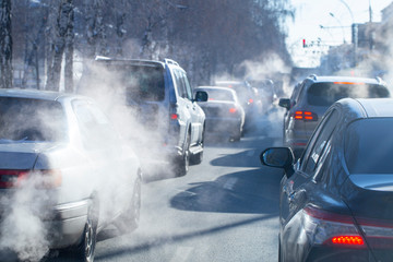 pollution from the exhaust of cars in the city in the winter. Smoke from cars on a cold winter day
