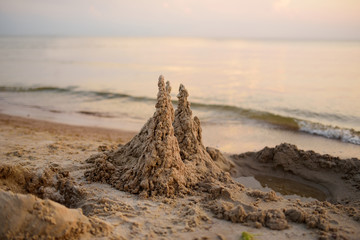 Sand castle built on the beach of Baltic sea on beautiful summer evening.