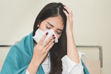 asian woman sneeze on the bed. unhealthy young female have cold and high temperature from fever and...