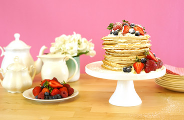 Shrove Pancake Tuesday, last day before Lent, stack of pancakes cake prepared with layers of whipped cream and fresh berries.