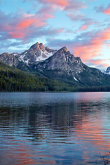 Sunset reflecting in lake over the Sawtooth Mountains near Stanley Idaho, USA - obrazy, fototapety, plakaty