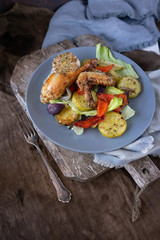 Portion pieces of grilled chicken and vegetable salad on blue ceramic plate