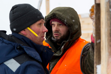 Two workers in overalls at a construction site