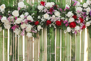 Fototapeta premium Colorful multicolored ornamental of beautiful red and pink roses flower blooming patterns group with daisy texture on bamboo wall natural for background