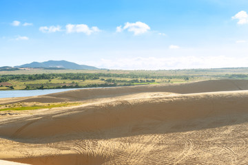Landscape view of sand dunes with car trail at White Sand Dunes, Mui Ne, Vietnam.