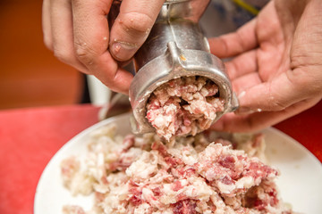 man examines a meat grinder