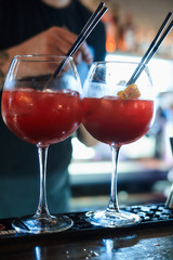 The barman creates alcoholic long drink coctails at the bar