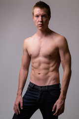 Studio shot of young handsome muscular shirtless man