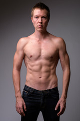 Fototapeta na wymiar Studio shot of young handsome muscular shirtless man
