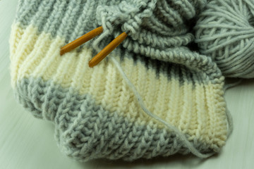 Knitted from a gray yarn and a thread for knitting close-up. Knitting as a hobby. Accessories for knitting