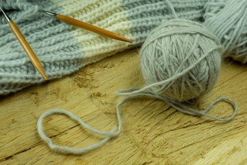 Knitted from a gray yarn and a thread for knitting close-up. Knitting as a hobby. Accessories for knitting