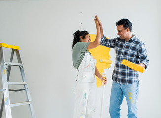 Fototapeta premium Couple giving a high five while renovating their new house