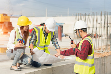 Civil engineers at construction site and a land surveyor using an altometer