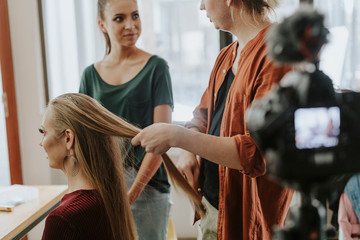 Hair stylist busy working with a model