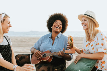 Friends singing together at a beach picnic - Powered by Adobe