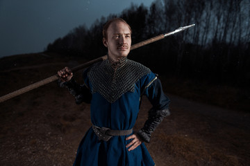 Medieval knight with sword and spear in ancient armour over Winter Landscapes