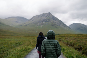 Obraz premium Couple of friends walking through the rain in Glen Etive, Scotland