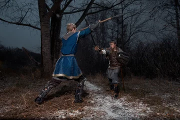 Tuinposter The battle between medieval knights in the style in winter forest Landscapes © Fotokvadrat