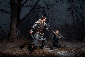 The battle between medieval knights in the style of Game of Thrones in winter forest landscapes. Spear against sword