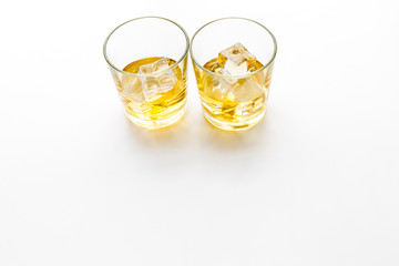 Glass of whiskey with ice on white background top view space for text