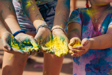 Teenagers on the Holi festival. Close up palms with colorful holi powder.