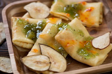 Freshly made crepes topped with fruit sauce and pear chips, selective focus, close-up
