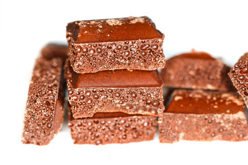 Delicious dark porous chocolate isolated on a white background close up