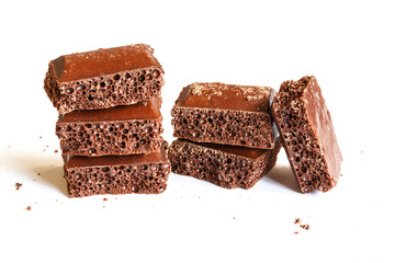 Delicious dark porous chocolate isolated on a white background close up