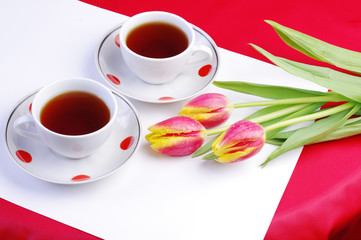 Tea for Two. Two cups of tea and a bouquet of tulips. Table service on Valentine's day.