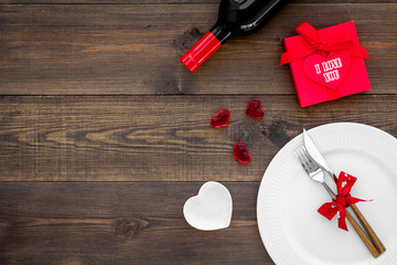 Romantic dinner with wine. Valentine's day. Decorated table, gift box on dark wooden background top view space for text