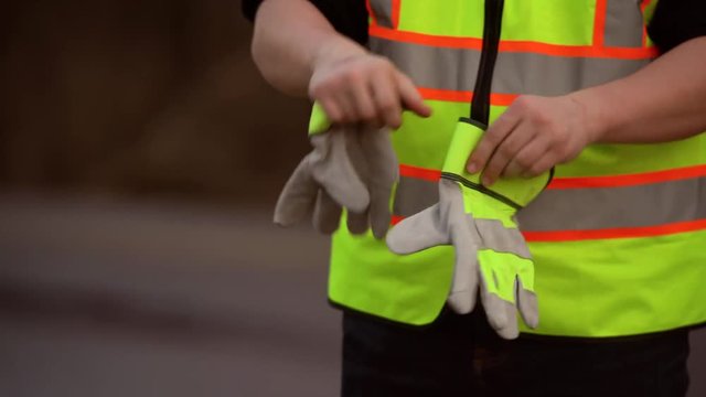 construction worker putting on gloves