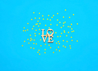 Festive turquoise background with gold spangles in the shape of heart. Concept Valentines Day or Mothers Day.
